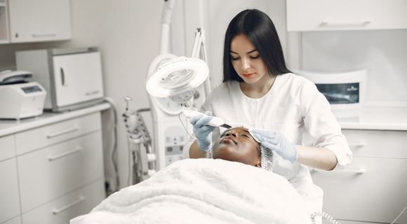 Aesthetician performing a facial treatment on a client in a med-spa clinic