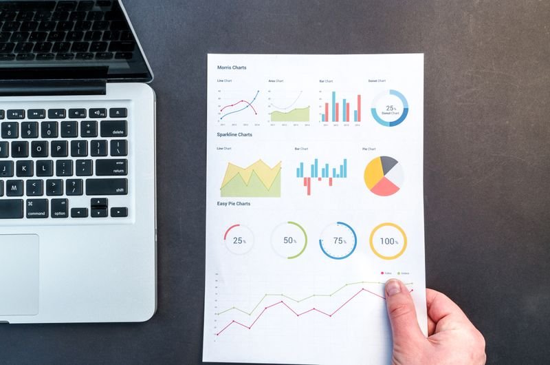 Person holding a bar chart representing competitor analysis data Person holding a bar chart representing competitor analysis data