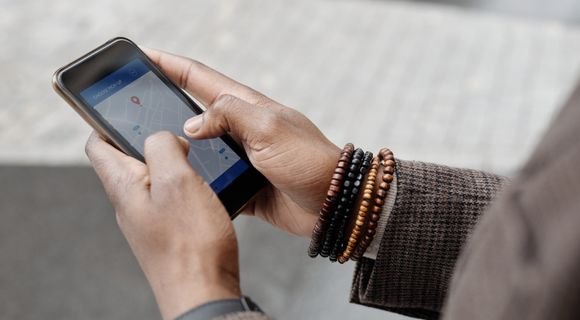 Person checking a map pin on their phone, the screen Google Maps SEO services compete for