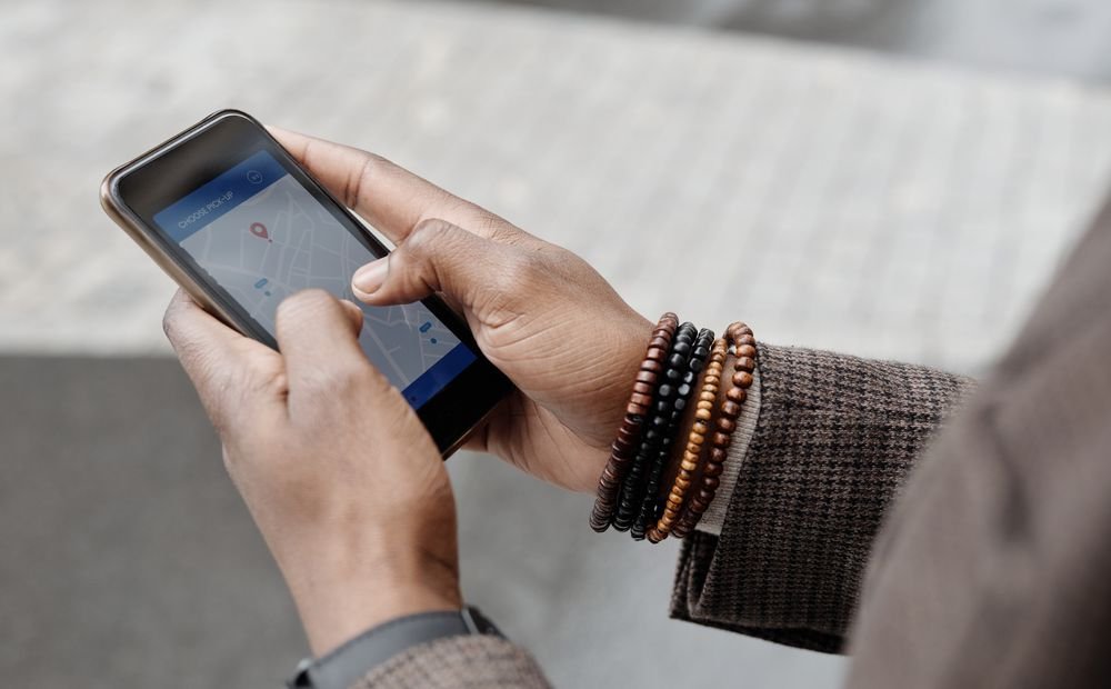 Person checking a map pin on their phone, the screen Google Maps SEO services compete for Person checking a map pin on their phone, the screen Google Maps SEO services compete for